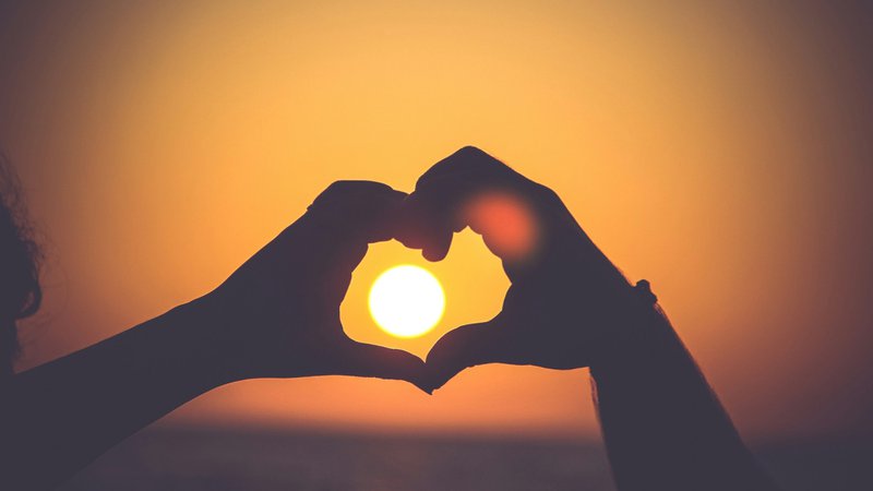 helping hands in a heart shape around the sun.